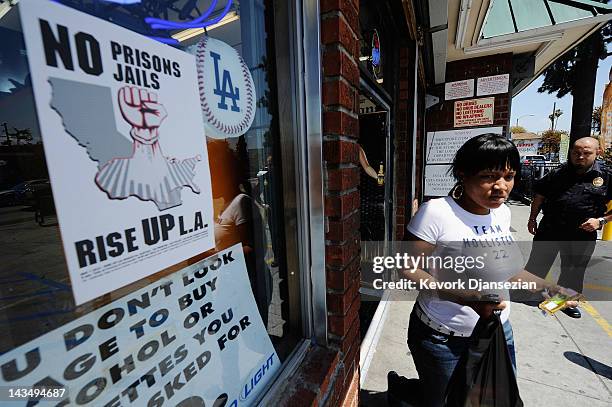 Security guard keeps watch outside Tom Liquor store at the intersection of Florence and Normandy Avenues South Los Angeles on April 27, 2012 in Los...