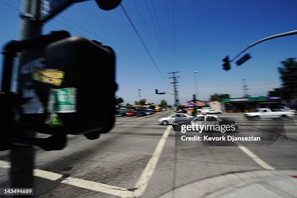 Los Angeles Police Department car with lights and sirens going rushes through the intersection at Florence and Normandy Avenues in South Los Angeles...