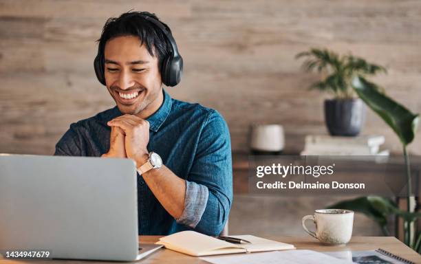 trabajador remoto, portátil y hombre asiático con auriculares en línea o feliz durante la videoconferencia en el escritorio con wifi. joven emprendedor freelance trabajando desde casa escuchando música de audio - espacio de trabajo virtual compartido fotografías e imágenes de stock