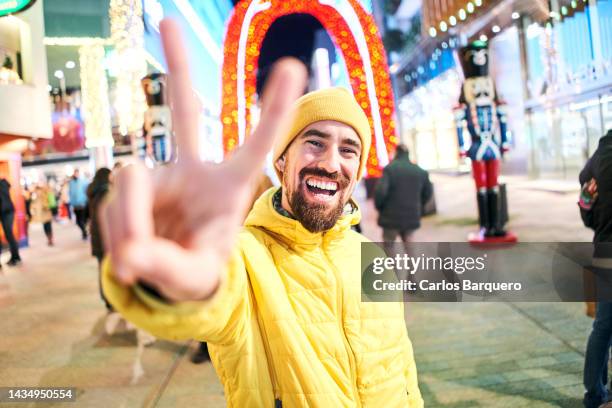happy caucasian man looking at camera with big toothy smile and doing the peace sign. - cnd sign stock pictures, royalty-free photos & images