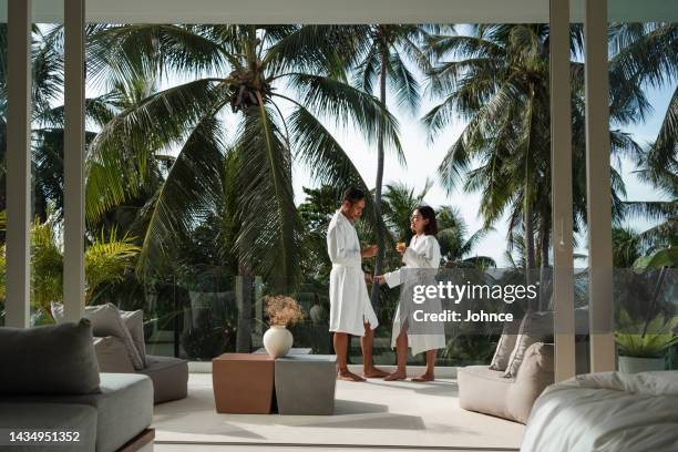 lächelndes paar entspannt sich auf einem balkon - couple balcony stock-fotos und bilder