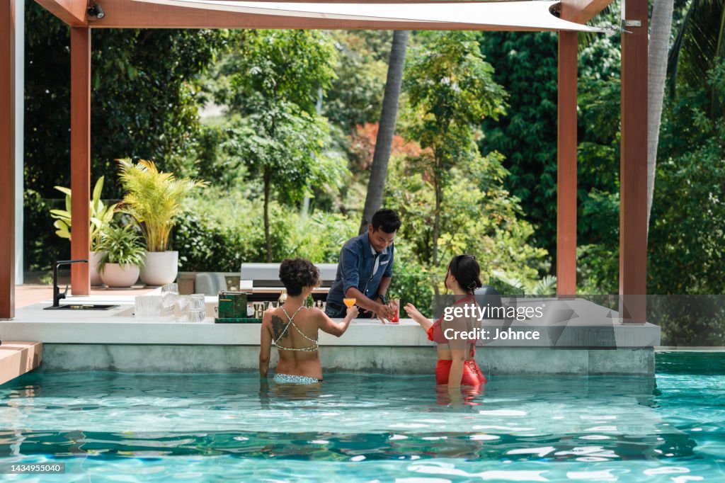 Des amies dégustent des cocktails au bar de la piscine