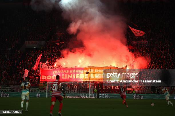 General view as fans of FC Augsburg use smoke flares as they hold up a banner which reads 'Dreams Can End But Our Love Never' during the DFB Cup...