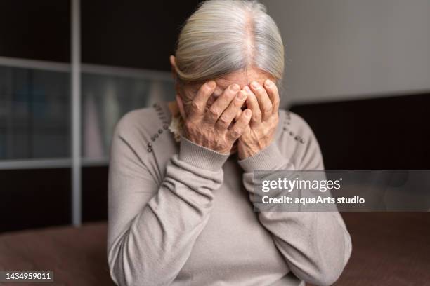 depressed lonely senior woman covered her face with both hands - grey hair stress stock pictures, royalty-free photos & images