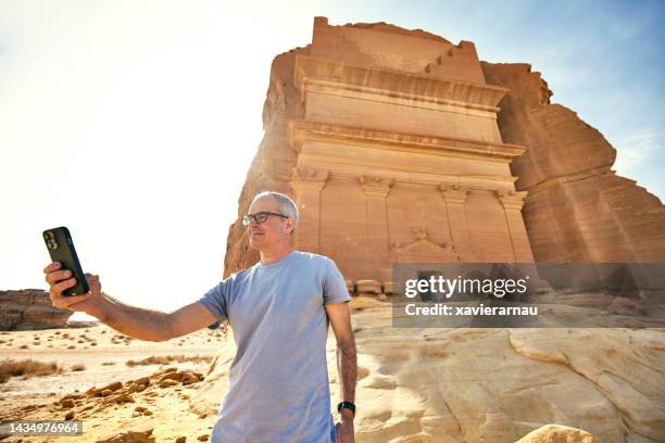 traveler taking selfie at tomb of lihyan, son of kuza - middle eastern male on phone isolated stock pictures, royalty-free photos & images