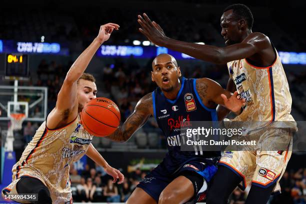 Xavier Rathan-Mayer of United drives to the basket under pressure from DJ Hogg of the Taipans and Majok Deng of the Taipans during the round four NBL...