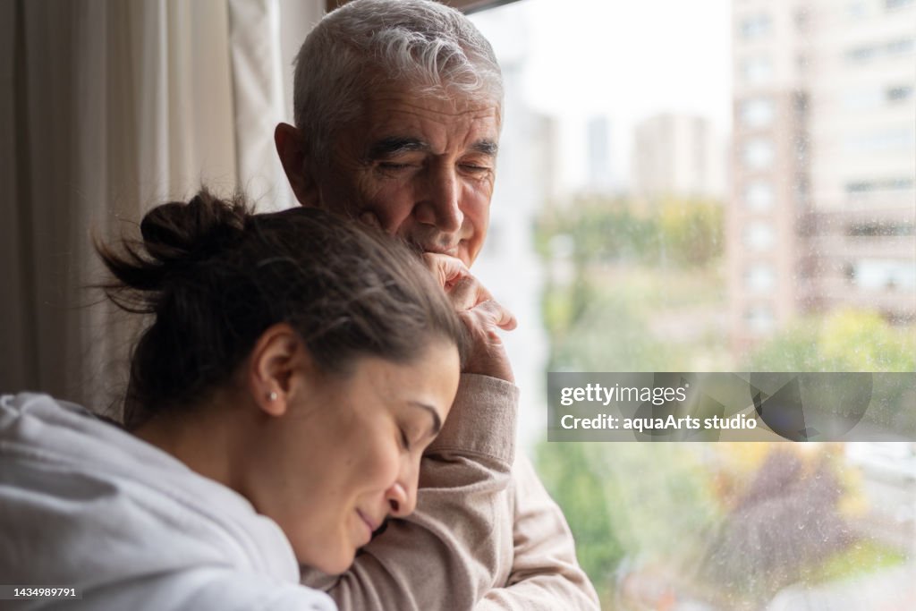 Figlia che abbraccia il suo padre anziano