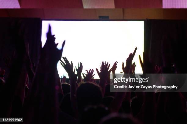 crowd silhouette at a performance - stage screen lights stock pictures, royalty-free photos & images
