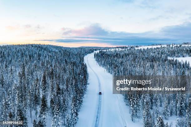 overhead view of car driving on a snowy road in a forest - off the beaten path foto e immagini stock