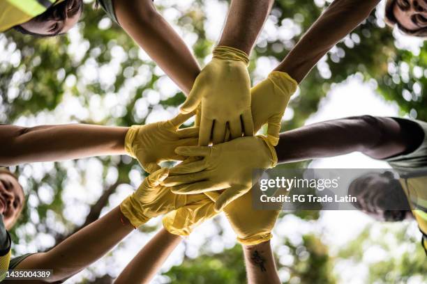 close-up of stack of hands outdoors - hand stack stock pictures, royalty-free photos & images