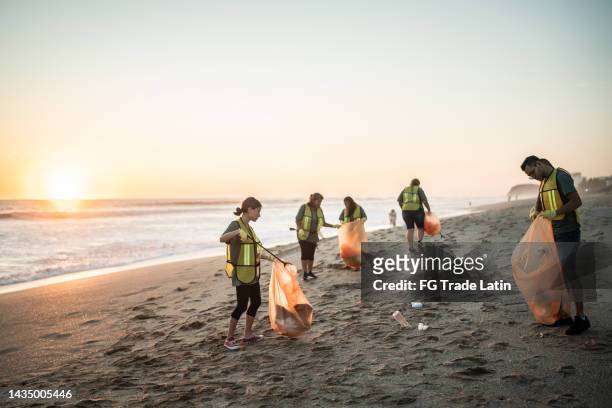 recyclers cleaning the beach - plastic pollution beach stock pictures, royalty-free photos & images