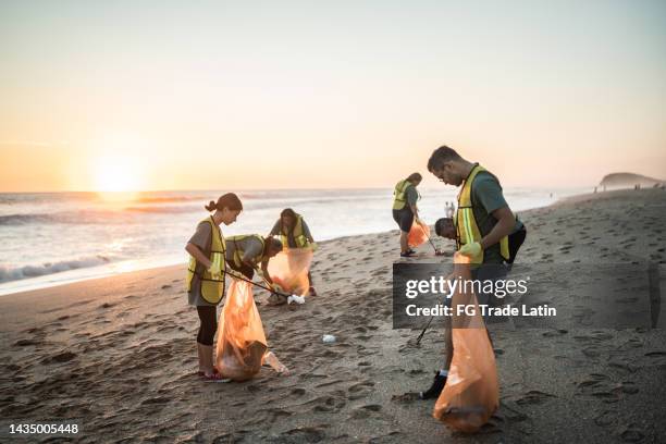 recycleurs nettoyant la plage - volunteer beach photos et images de collection