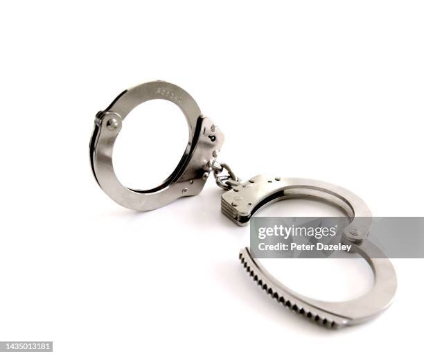 handcuffs on white background - tax fraud stock-fotos und bilder