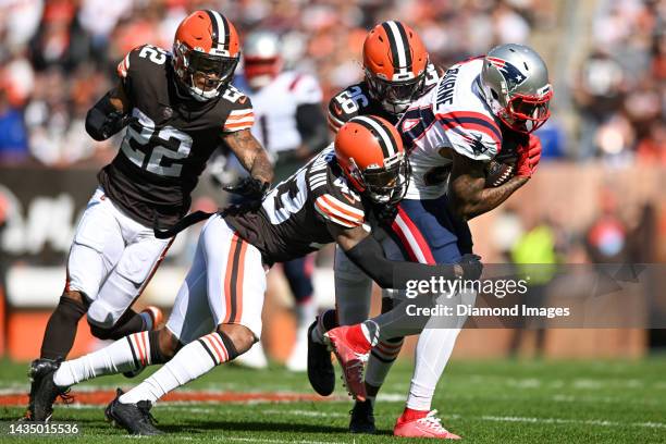 Greedy Williams and John Johnson III of the Cleveland Browns tackle Kendrick Bourne of the New England Patriots during the first half at FirstEnergy...