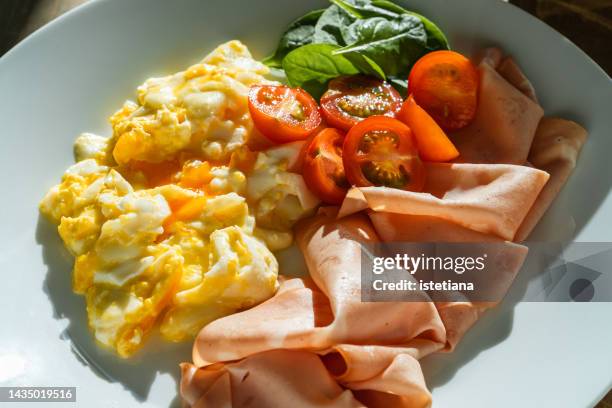 breakfast plate. scrambled eggs with mozzarella, slices of mortadella, fresh vegetables on white plate - fromage vert photos et images de collection
