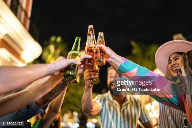nahaufnahme von freunden, die einen feiertoast im freien machen - mexican beer stock-fotos und bilder