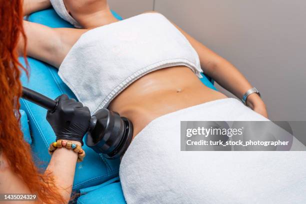 massagem vibratória g5 para emagrecimento regional é aplicada a uma mulher em salão de beleza - tighten - fotografias e filmes do acervo