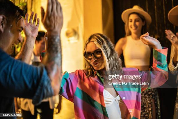 young woman having fun while dancing with her friends on the street at night - colour street dance stock pictures, royalty-free photos & images