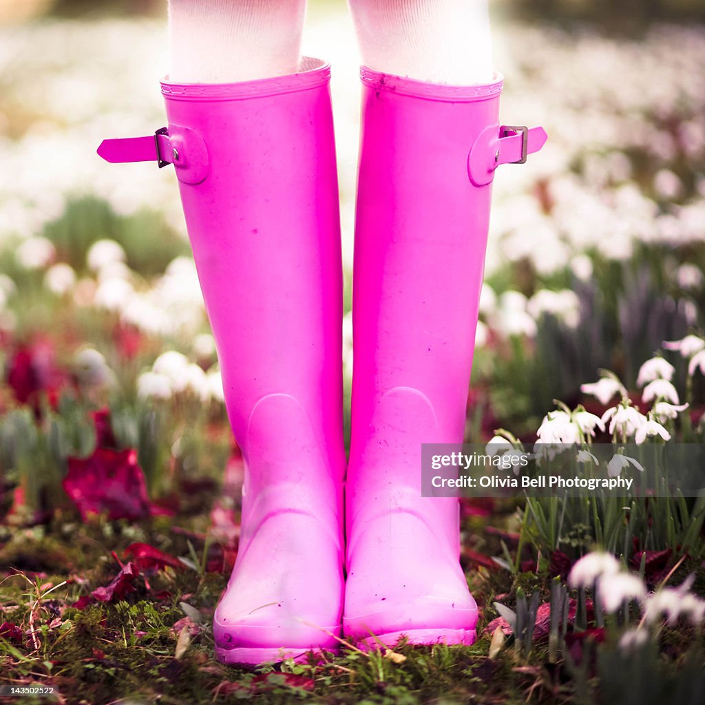 Girl standing in woodland of snowdrops