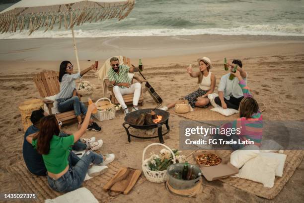 friends making a celebration toast on the beach - mexican picnic stock pictures, royalty-free photos & images