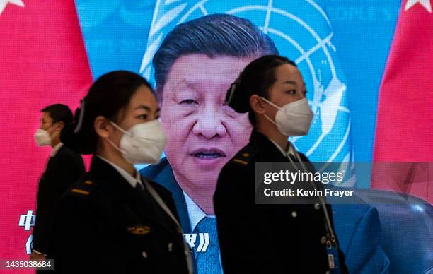 Large screen shows an image of Chinese President Xi Jinping as security guards wait to check visitors at the press centre for the 20th National...