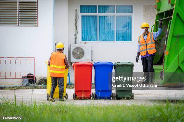 two men in uniform collecting garbage at city,trash and rubbish collection. - garbage truck driving stock pictures, royalty-free photos & images