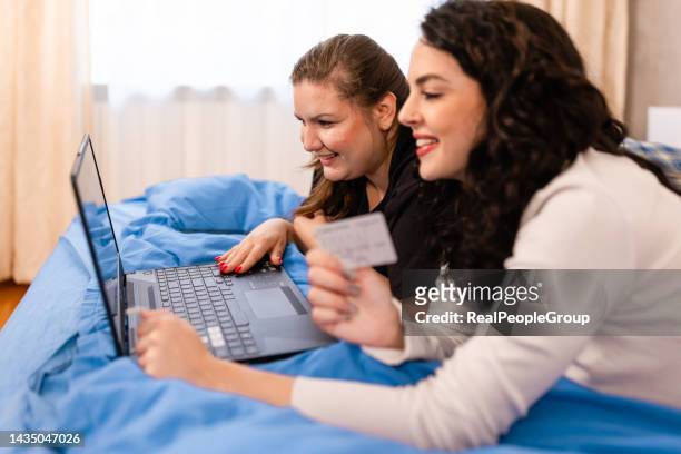 lesbianas que tienen una compra en línea en casa - chubby credit fotografías e imágenes de stock