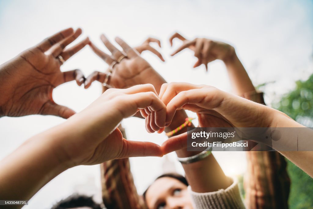 Conceptual shot of some hands making heart shapes with fingers
