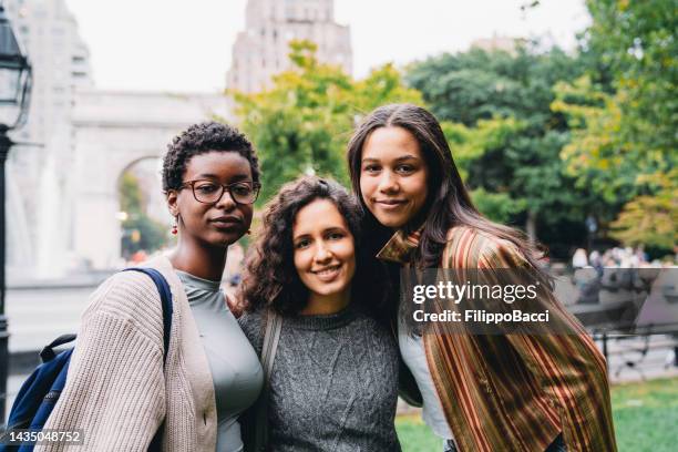 portrait of three friends in the city - washington square park stockfoto's en -beelden