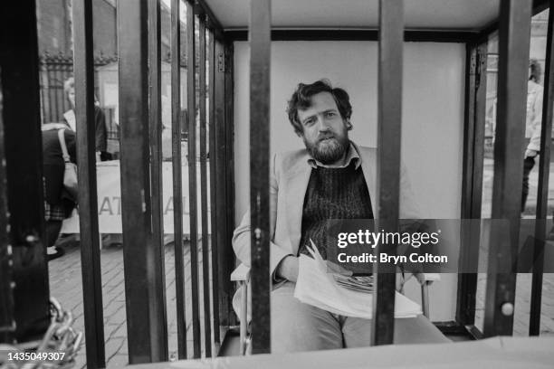 British Labour Party MP for Islington North, Jeremy Corbyn, sits inside a locked cage during an Amnesty International event in Covent Garden, in...