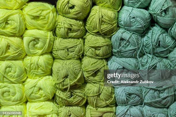 colorful background of multicolored yarn for knitting, crocheting. a lot of balls of wool yarn lie in rows according to the color, on the shelf in the store. handmade concept, favorite hobby, yarn sale. creating clothes with your own hands. do it yourself - gomitolo di lana foto e immagini stock