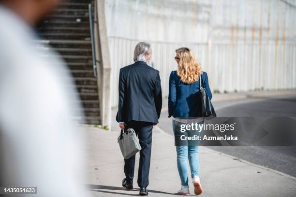 two business workers walking together outdoors towards the stairs - detrás para frente imagens e fotografias de stock