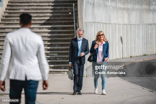 businesspeople leaving the office together and walking to the parking lot - looking backwards stock pictures, royalty-free photos & images