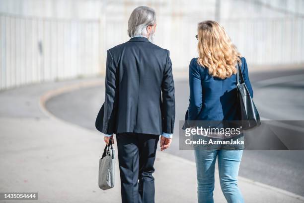 two business workers walking together outdoors - looking backwards stock pictures, royalty-free photos & images
