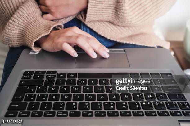 cropped shot of unrecognizable woman using touchpad of laptop while surfing the net to pass the time - apendicitis fotografías e imágenes de stock