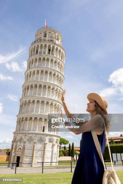 happy tourist holding the leaning tower of pisa - torre de pisa imagens e fotografias de stock