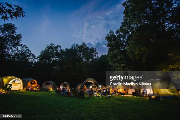 large group of tents illuminated as the night falls over camp - "marilyn nieves" stock pictures, royalty-free photos & images