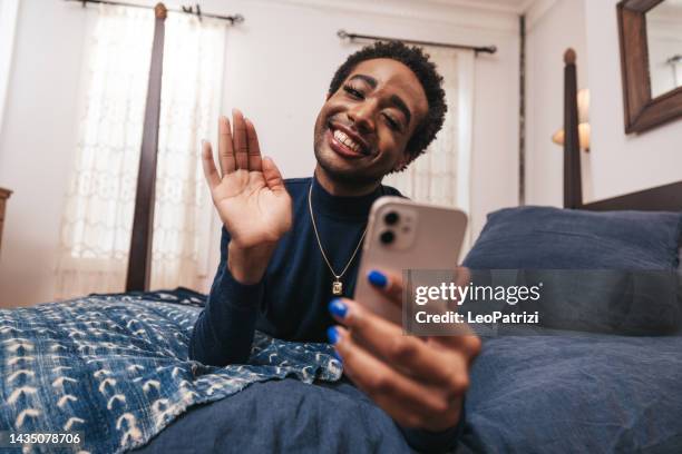 non-binary person at home. he/she waving to friends in video call - non binary stereotypes stock pictures, royalty-free photos & images