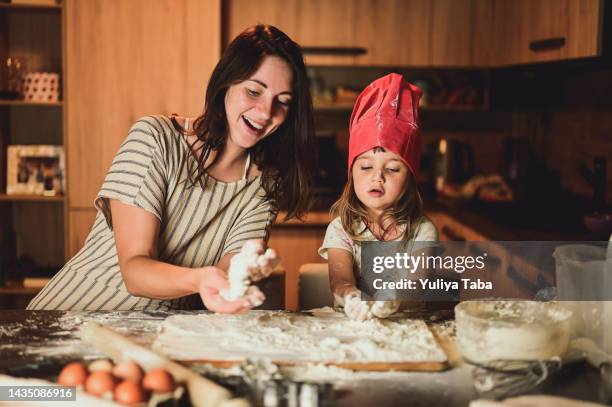 family in a kitchen. beautiful mother with little daughter making the dough. happy family in kitchen - sweetie pie stock pictures, royalty-free photos & images