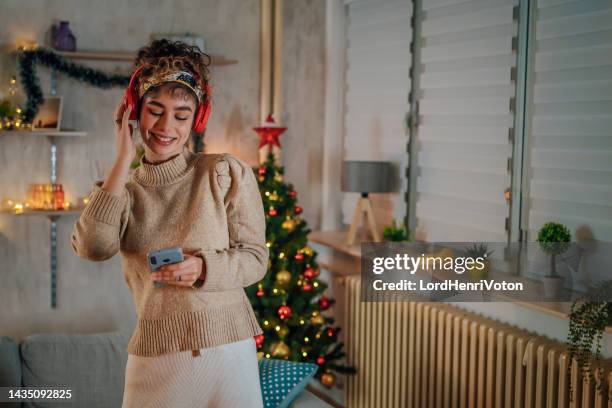 mujer escuchando música y bailando - christmas music fotografías e imágenes de stock