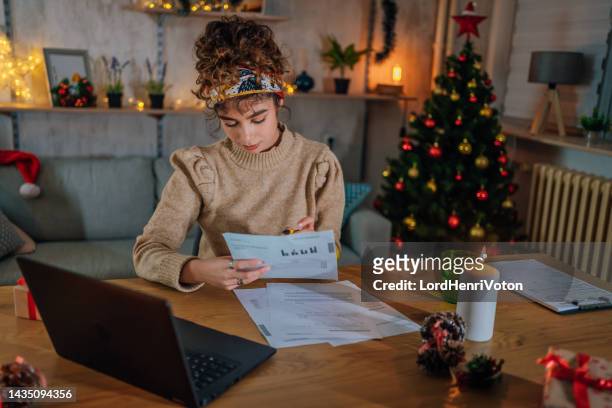 woman managing finances in the evening - christmas budget stock pictures, royalty-free photos & images