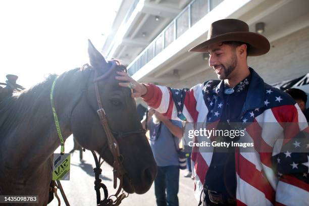 Daniel Ricciardo of Australia and McLaren pets a horse in the Paddock during previews ahead of the F1 Grand Prix of USA at Circuit of The Americas on...