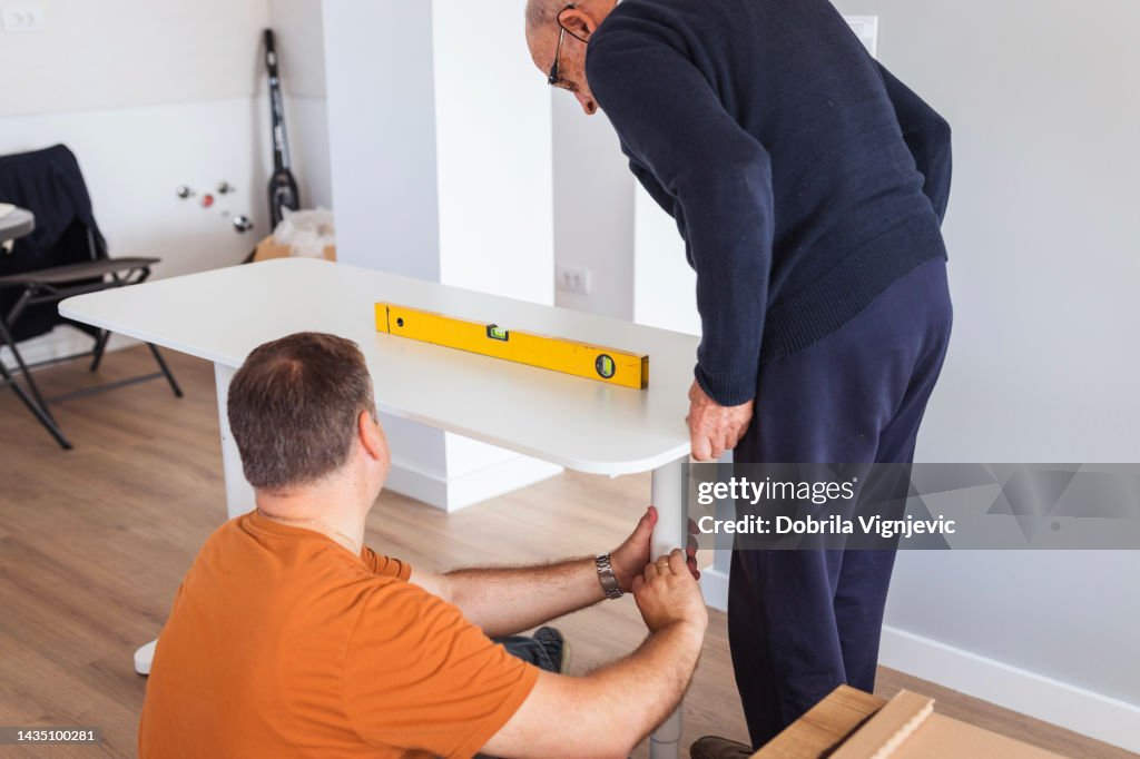 Men Using Leveling Scale On A New Desk High-Res Stock Photo - Getty Images