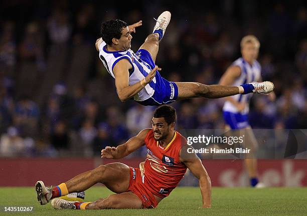 Lindsay Thomas of the Kangaroos collides with Karmichael Hunt of the Suns in a marking contest during the round five AFL match between the North...