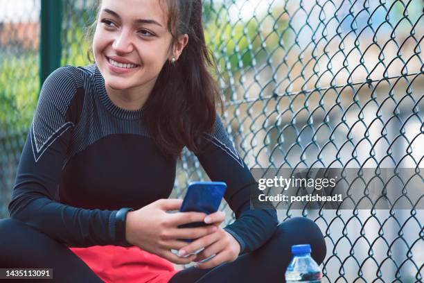 portrait of a smiling teenage girl resting after doing sports - daily sport girls bildbanksfoton och bilder