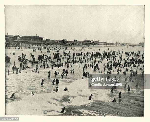 people in the sea and on the beach at atlantic city, new jersey, victorian 19th century, vintage photograph - new jersey beach stock illustrations