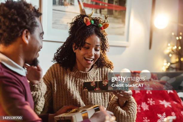 christmas gift exchange at home - christmas gift giving stock pictures, royalty-free photos & images