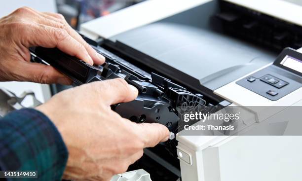 close-up technician changing cartridge inks in a computer printer - cartridge stock pictures, royalty-free photos & images
