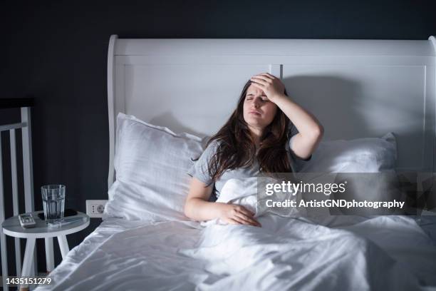 mujer acostada en la cama porque está enferma. - enfermedad crónica fotografías e imágenes de stock
