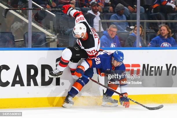 Alexander Romanov of the New York Islanders checks Tomas Tatar of the New Jersey Devils in the second period of the game at UBS Arena on October 20,...